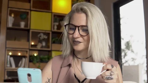Coffee break. Female using smartphone while drinking coffee Stock Footage 85334811