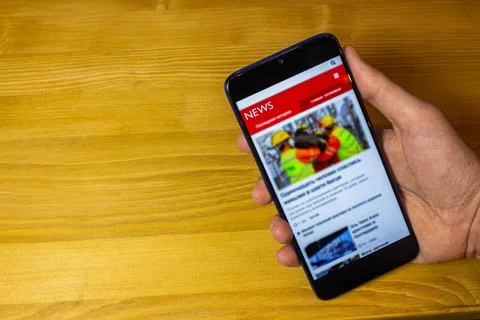 Coffee break in the office while reading news on the cellphone. 写真素材