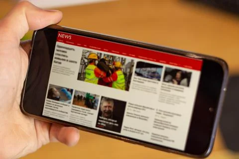 Coffee break in the office while reading news on the cellphone. Stock Photos