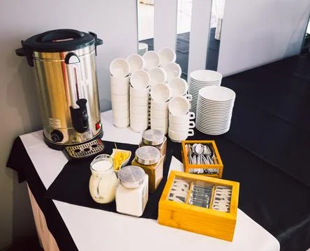 Coffee break setup with cups, milk, sugar and tea bags at business event Stock Photos