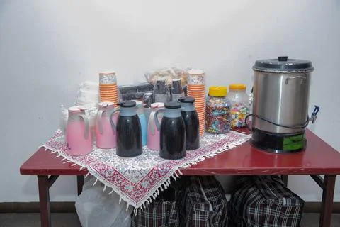 Coffee break table setting with thermal flasks, paper cups, candies, and a large Stock Photos
