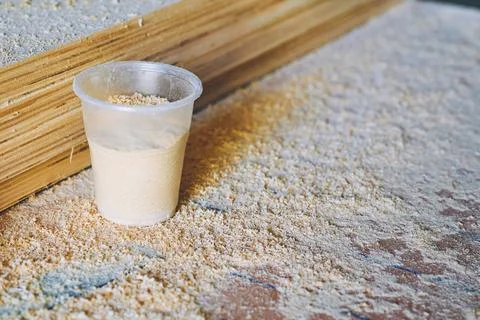 Coffee break, tea time in workshop.A plastic cup,sawdust,carpenter's workbench Stock Photos