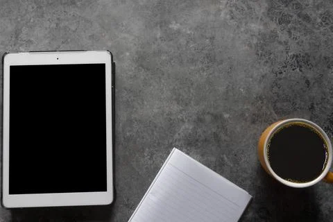 Coffee break. Top view yellow cup of coffee with tablet and Note paper on a t Stock Photos