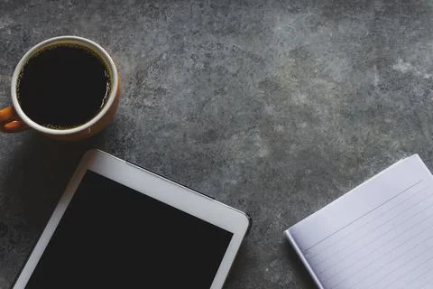 Coffee break. Top view yellow cup of coffee with tablet and Note paper on a t Stock Photos