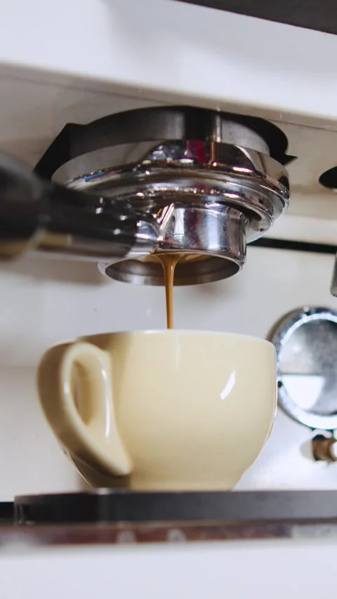 Coffee brews from an espresso machine at an artisan cafe where a skilled barista Stock Footage 330789365