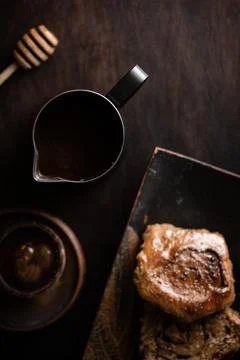 Coffee with a bun on a dark background Stock Photos