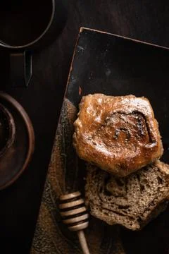 Coffee with a bun on a dark background Stock Photos
