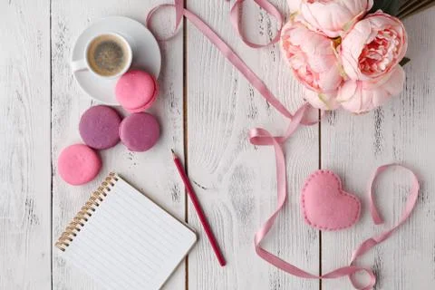 Coffee, cake macaron, clean notebook, eyeglasses and flower on pink table fro Fotos Stock