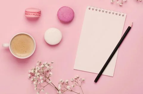 Coffee, cake macaron, clean notebook, eyeglasses and flower on p Stock Photos