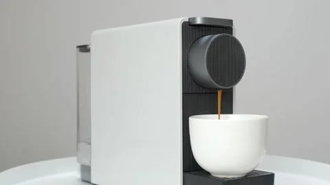 Coffee from capsule coffee machine is poured into white cup. Stock Footage 269124497