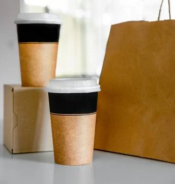 Coffee in cardboard brown cups ordered and delivered for takeaway, food delivery Stock Photos