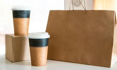 Coffee in cardboard brown cups ordered and delivered for takeaway, food delivery Stock Photos