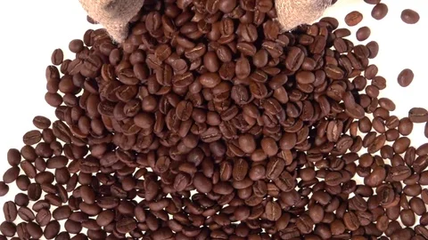 Coffee. Coffee beans are poured from the jute bag onto a white table. Stockbeeldmateriaal 81828102