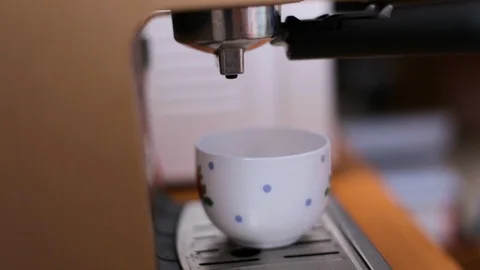 Coffee from a coffee machine is poured into a white cup Stock Footage 107411746