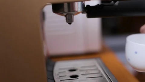 Coffee from a coffee machine is poured into a white cup Stock Footage 107415519