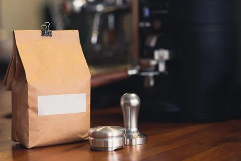 Coffee concept, an elegant pack of coffee beans and coffee tamper view from a 스톡 사진