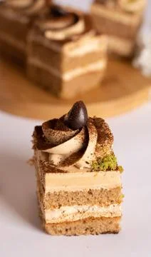 Coffee cream layer cake cube topped with chocolate swirl and coffee bean Stock Photos