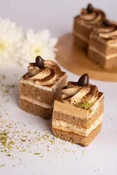 Coffee cream layer cake cube topped with chocolate swirl and coffee bean Stock Photos