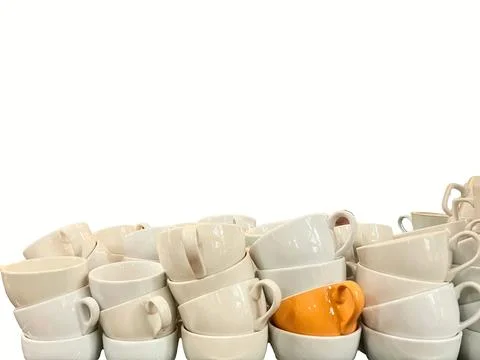 Coffee culture concept, stack of white with one orange ceramic coffee cups .. Stock Photos