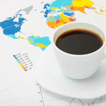 Coffee cup above world map and some financial documents 库存照片