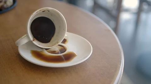 A coffee cup accidentally spills on the table, accompanied by its saucer, in a Stock Footage 346876542