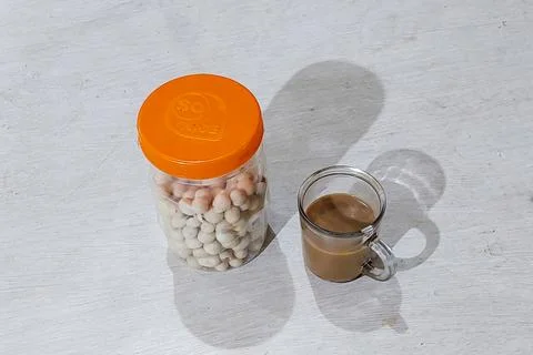 The coffee is in the cup and the beans are on the table ready to be eaten Фото