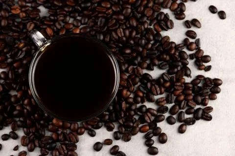 Coffee cup and beans on the kitchen table. Stock Photos