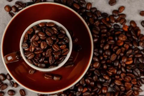 Coffee cup and beans on the kitchen table. Stock Photos