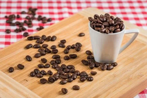 Coffee cup and beans on a rustic table Stock Photos