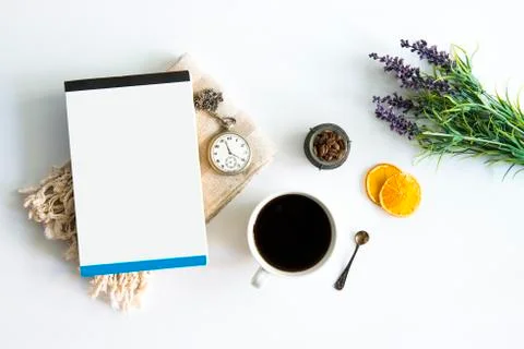 Coffee cup and book on table with dried oranges and old pocket watch green leaf. Stock Photos
