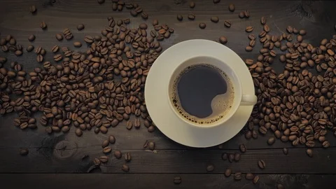 Coffee cup and coffee beans on a black wooden table Stock Footage 107939430