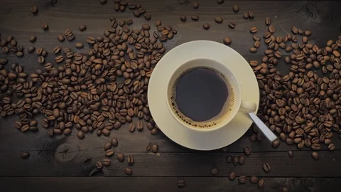 Coffee cup and coffee beans on a black wooden table Stock Footage 107939567