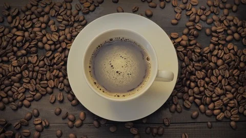 Coffee cup and coffee beans on a black wooden table Stock Footage 107939726