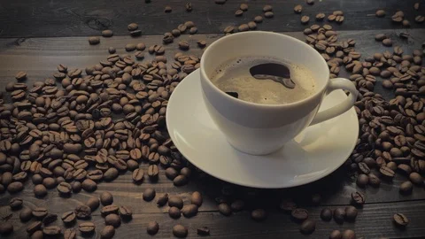 Coffee cup and coffee beans on a black wooden table Stock Footage 107939813