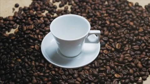 Coffee cup and coffee beans. White cup of evaporating coffee on the table with Stock Footage 113425720
