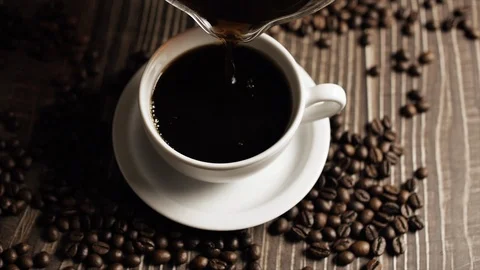 Coffee cup and coffee beans. White cup of evaporating coffee on the table with Stock Footage 121806973