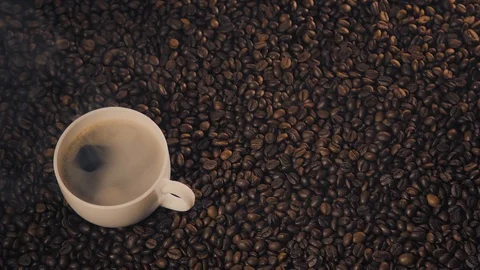 Coffee cup and coffee beans. A white cup of evaporating coffee on the table with Stock Footage 126409152