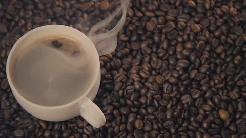 Coffee cup and coffee beans. A white cup of evaporating coffee on the table with Stock Footage 126418722