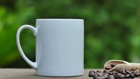 Coffee cup and coffee beans on an old wooden table,  white ceramic mug. Video stock 197452383