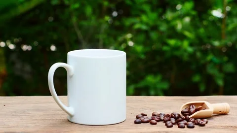 Coffee cup and coffee beans on an old wooden table,  white ceramic mug. 스톡 동영상 197452712