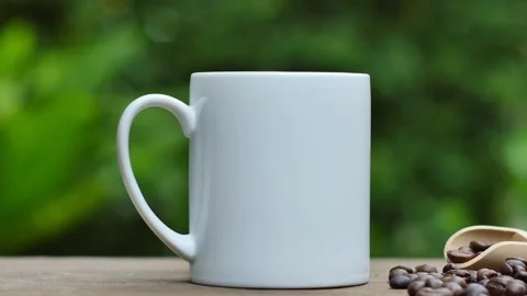Coffee cup and coffee beans on an old wooden table,  white ceramic mug. 스톡 동영상 197453837