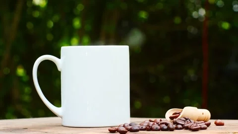 Coffee cup and coffee beans on an old wooden table,  white ceramic mug. 스톡 동영상 197453880