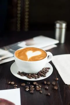 Coffee cup and coffee beans on wooden table. Stock Photos