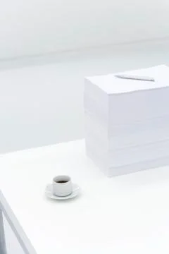 Coffee cup and large stack of documents on desk Foto stock