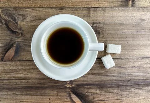 Coffee in a cup and sugar on the table, top view. Stock Photos
