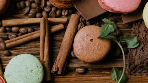 Coffee cup, beans, chocolate and color macaroons on the table. Stock Footage 88435359