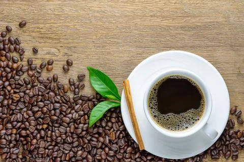 Coffee cup with beans on wood table Stock Photos