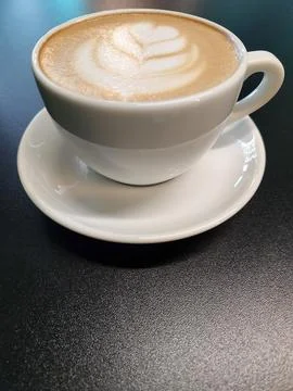 Coffee in a cup on a black background. Brewed coffee in a porcelain cup. Stock Photos