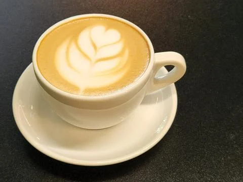 Coffee in a cup on a black background. Brewed coffee in a porcelain cup. Stock Photos