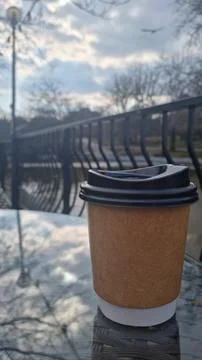 Coffee cup with blank space for text on table with urban park background Stock Photos